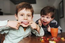 Boys making faces at table — Stock Photo