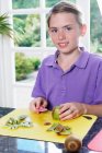 Enfant préparant à manger kiwi pelant les fruits — Photo de stock