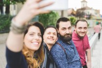 Group of friends taking selfie by roadside together — Stock Photo