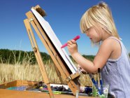 Retrato de menina pintura em um campo — Fotografia de Stock