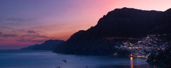 Bâtiments à flanc de falaise dans la baie illuminée la nuit, Positano, Côte amalfitaine, Italie — Photo de stock
