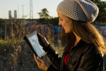 Junge Frau blickt auf digitalen Tablet-Bildschirm — Stockfoto