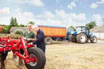 Bauern justieren Maschinen auf dem Feld — Stockfoto