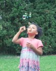 Girl blowing bubbles outdoors — Stock Photo