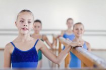 Ballet dancers standing at barre — Stock Photo