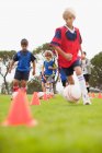 Детская футбольная команда тренируется на поле — стоковое фото