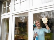 Donna che pulisce la finestra — Foto stock
