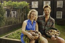 Couple with harvested potatoes and beets on council estate allotment — Stock Photo