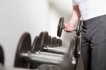 Человек, использующий свободные веса в спортзале — стоковое фото