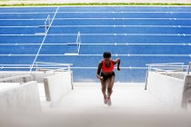 Frau rennt Stadiontreppe hinauf — Stockfoto