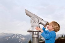 Хлопчик дивиться через телескоп на відкритому повітрі — стокове фото