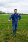 Портрет фермера, опирающегося на вилку в поле — стоковое фото