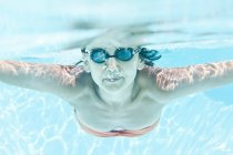 Mulher de óculos nadando na piscina, vista subaquática — Fotografia de Stock