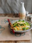 Bowl of noodles with vegetables and chopsticks — Stock Photo