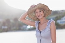 Donna che indossa cappello di paglia sulla spiaggia — Foto stock
