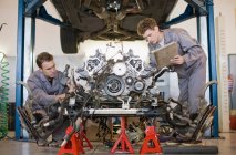 Механики, работающие над автомобильным двигателем — стоковое фото