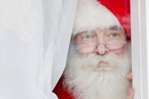 Papai Noel olhando pela janela — Fotografia de Stock