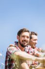 Portrait of two young men against blue sky — Stock Photo
