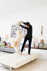 Женщина играет с собакой в гостиной — стоковое фото