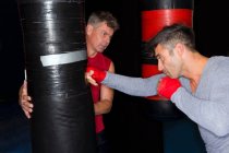 Boxeador trabajando con entrenador en gimnasio - foto de stock