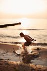 Підлітковий хлопчик грає у воді — стокове фото
