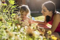 Мать и маленькая дочь ухаживают за садом — стоковое фото