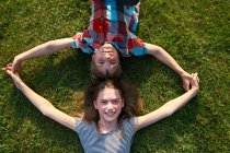 Дети, лежащие в траве вместе — стоковое фото