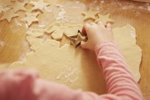 Sur l'épaule recadrée vue de fille faisant pâtisserie en forme d'étoile à la table de cuisine — Photo de stock