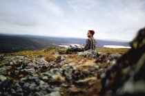 Турист, наслаждающийся видом на вершину скалы, Омиотунтури, Остленд, Финляндия — стоковое фото