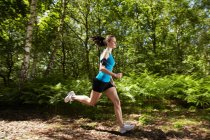 Frau läuft in Wald — Stockfoto