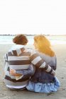 Una coppia che guarda il tramonto su una spiaggia — Foto stock