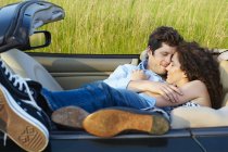 Paar legt sich in ein Cabrio — Stockfoto