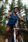 Baixo ângulo vista de Man mountain bike na floresta — Fotografia de Stock