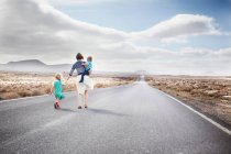 Familie zu Fuß auf asphaltierter Landstraße — Stockfoto