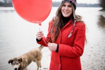 Junge Frau mit Ballon läuft Hund — Stockfoto