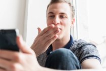 Homem soprando beijo no telefone móvel — Fotografia de Stock
