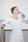 Balletttänzer trinkt Wasser im Studio — Stockfoto