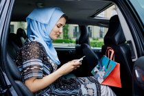 Femme en foulard utilisant un téléphone portable — Photo de stock