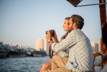 Романтическая пара рассматривает камеру на лодке в Дубае, Объединенные Арабские Эмираты — стоковое фото