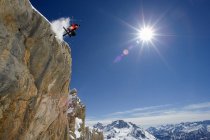Лыжник в воздухе на снежной горе — стоковое фото