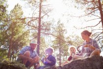 Famiglia che fa un picnic seduto sulle rocce — Foto stock