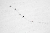 Воздушный вид на заснеженные горы с удаленной группой туристов — стоковое фото