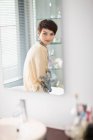 Woman in robe sitting in bathroom — Stock Photo