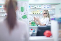 Pharmacist looking at box of medication — Stock Photo