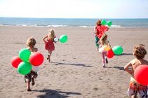 Мати з чотирма дітьми на пляжі з повітряними кулями (Уельс, Велика Британія). — стокове фото