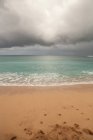 Nube de tormenta sobre la playa de arena - foto de stock