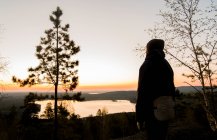 Tourist enjoying view of lake at sunset — Stock Photo