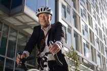 Portrait of Businessman riding bicycle — Stock Photo