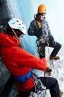 Ice climbers in ice cave preparing climbing equipment — Stock Photo