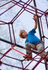 Garçon grimpant à l'aire de jeux — Photo de stock
